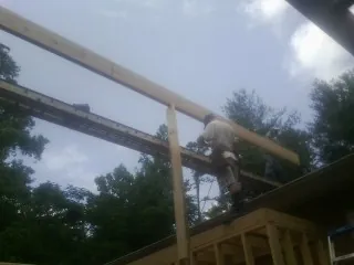 Carpenter setting a ridge beam over a new addition frame — Ice Dam Removal by Roofing Brothers in Wood Ridge