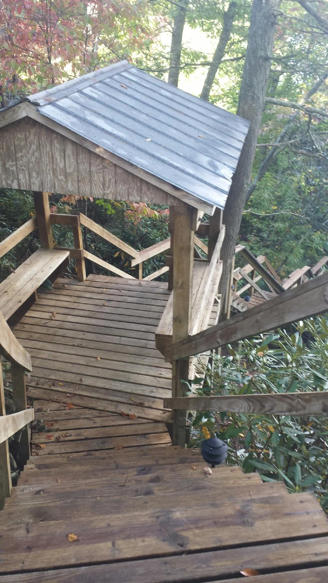 Metal roofed shelter over wooden steps on a wooded walkway — Skylight Repair & Installation work by our crew in Wood Ridge